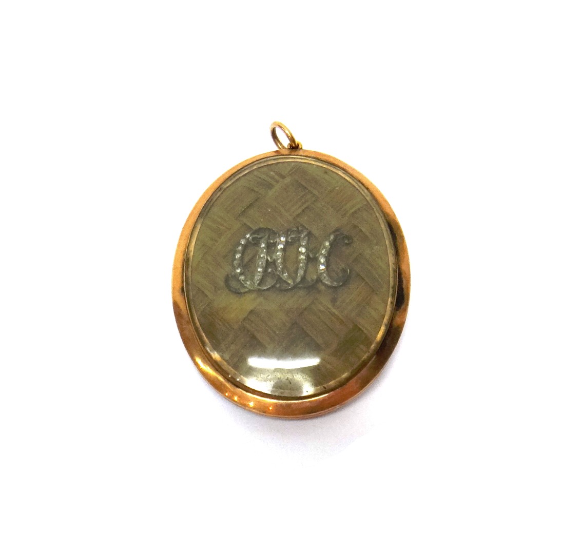 Appraisal: An early th century glazed oval pendant displaying interwoven hairwork