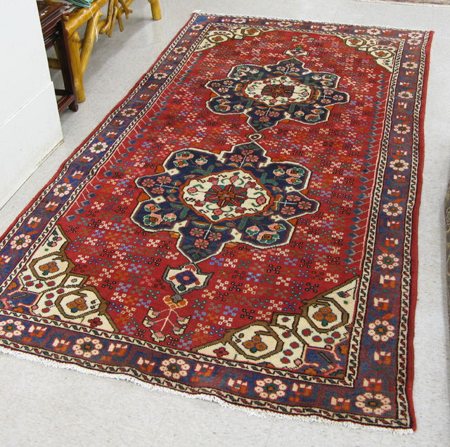 Appraisal: PERSIAN TRIBAL AREA RUG double flower-filled geometric medallion design on