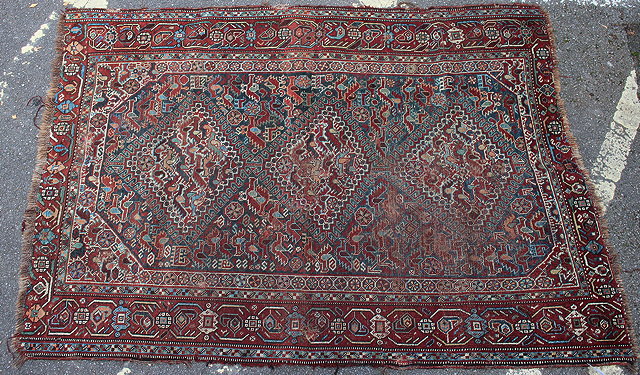 Appraisal: AN OLD ORIENTAL BLUE GROUND RUG centrally decorated with three