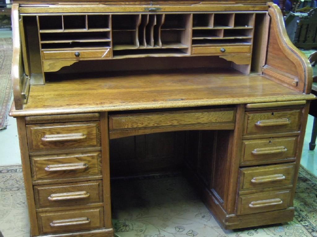 Appraisal: An Edwardian oak roll top kneehole pedestal desk the 'S'