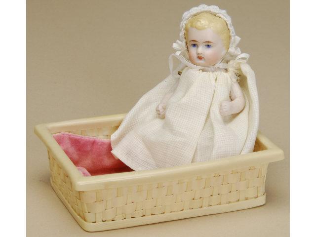 Appraisal: All Bisque Baby in Celluloid Basket Germany ca celluloid baby