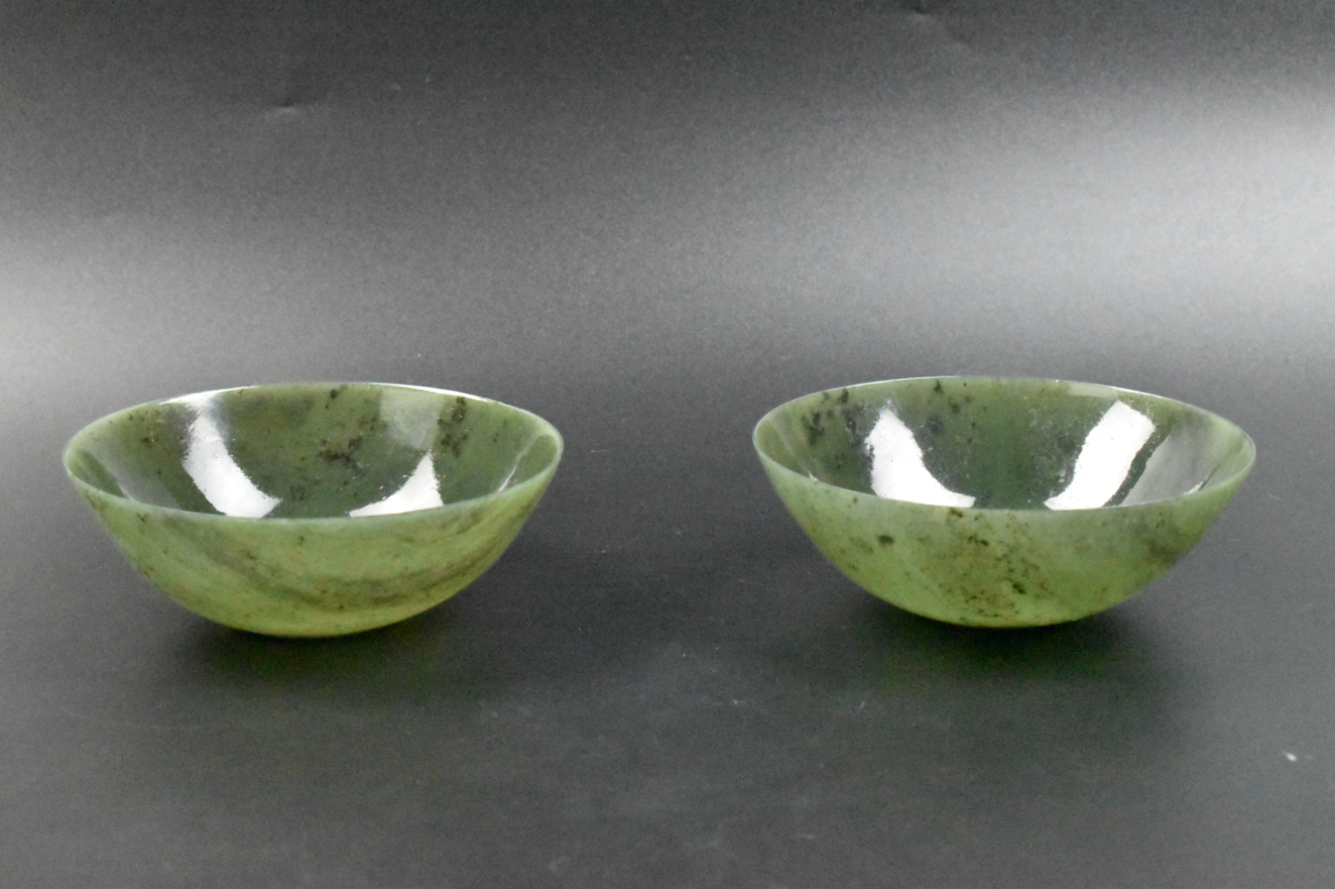 Appraisal: A pair of Chinese green jade bowls Two green jade