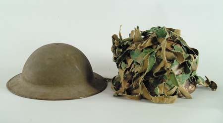 Appraisal: TWO MILITARY HELMETS Vietcong metal with camouflage strips WWI helmet