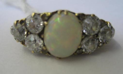 Appraisal: AN OPAL AND DIAMOND DRESS RING the central oval cabochon