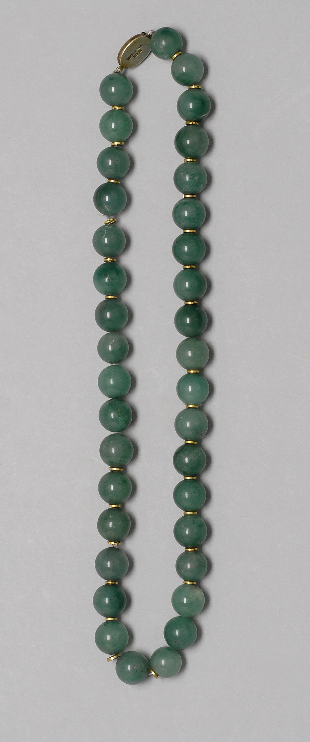 Appraisal: SERPENTINE BEADED NECKLACE Thirty-six mm beads interspersed with gold-colored spacers