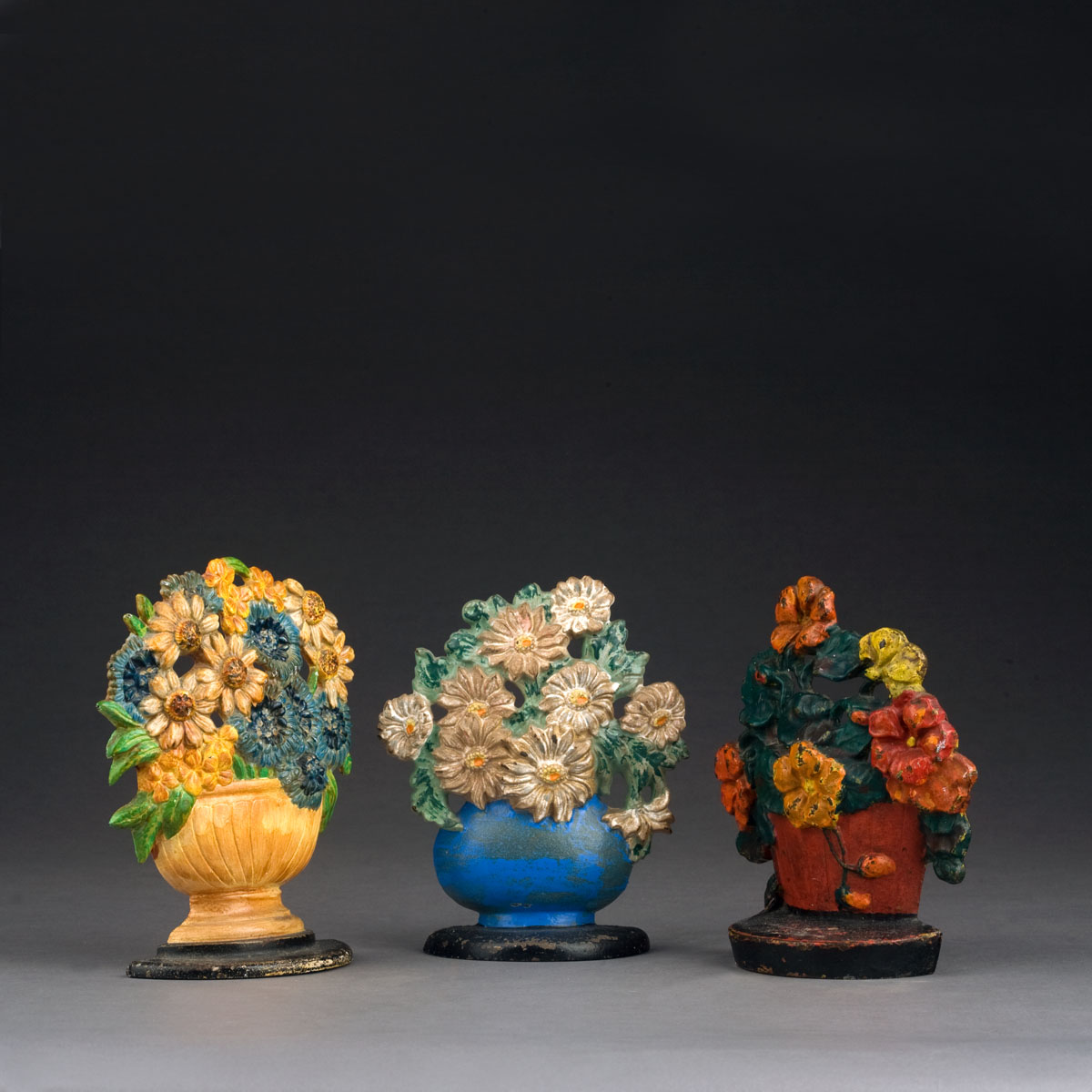 Appraisal: THREE CAST-IRON FLORAL DOORSTOPS Height of tallest inches