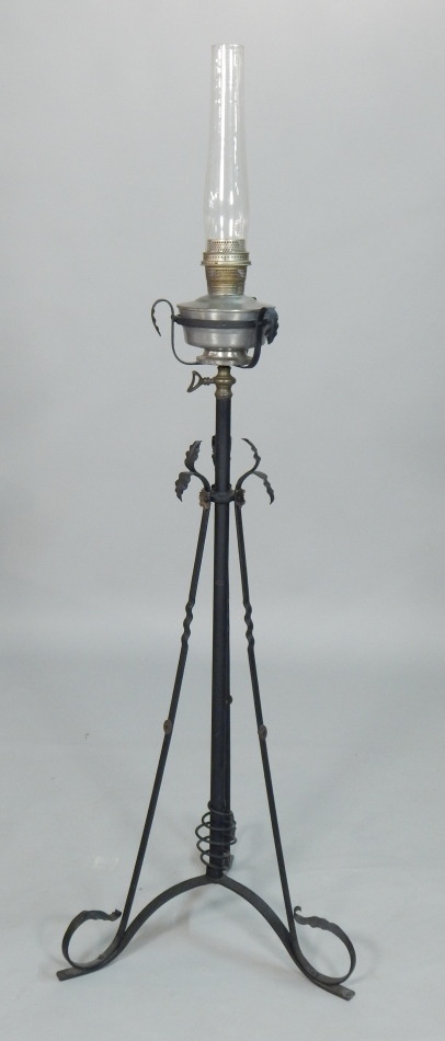 Appraisal: An Edwardian wrought iron floor standing oil lamp decorated with