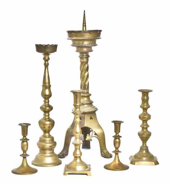 Appraisal: An Ecclesiastic Brass Pricket Stick together with four brass candlesticks