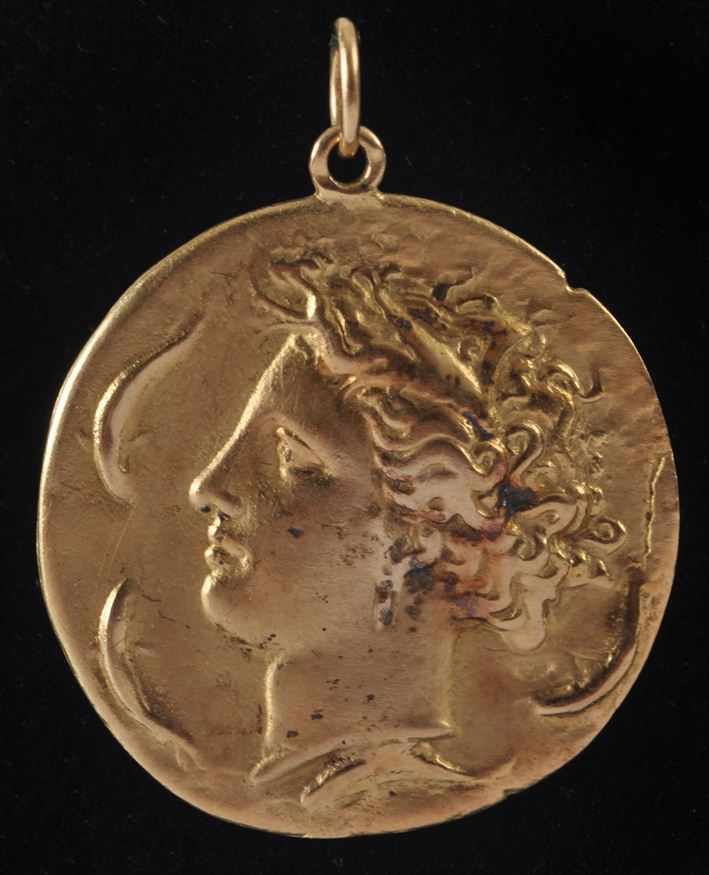 Appraisal: SEAMAN SCHEPPS GOLD PENDANT IN THE FORM OF A SYRACUSAN