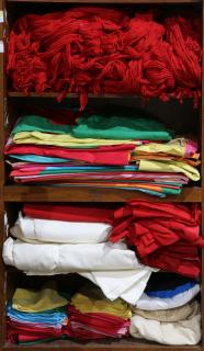 Appraisal: Four shelves of textiles and linens Four shelves of textiles