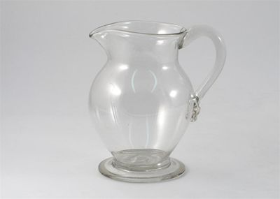 Appraisal: A glass jug raised on a circular foot the handle