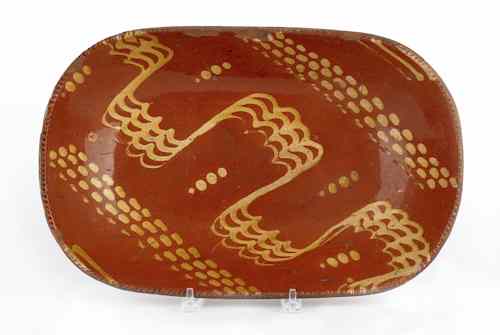 Appraisal: Large redware loaf dish th c with vibrant trailing slip