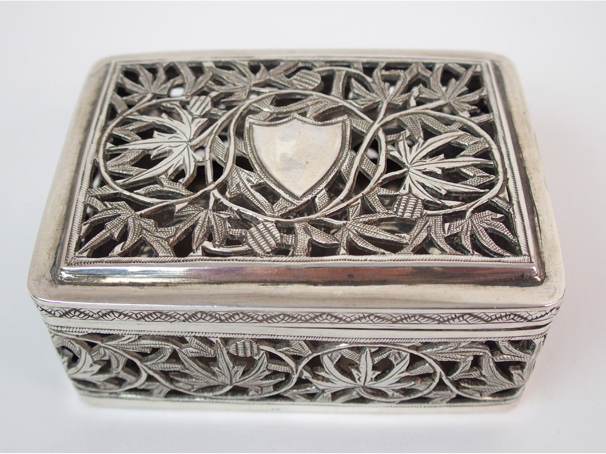 Appraisal: An Asian white metal pierced boxdecorated with scrolling foliage enclosing