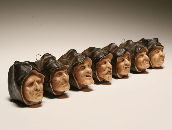 Appraisal: Plaster hooded monks' heads hanging candle holder seven distictive coutenances