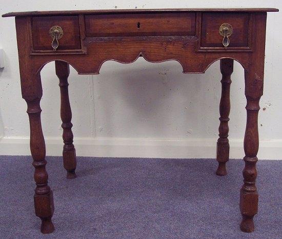 Appraisal: An oak kneehole table of th Century design the top