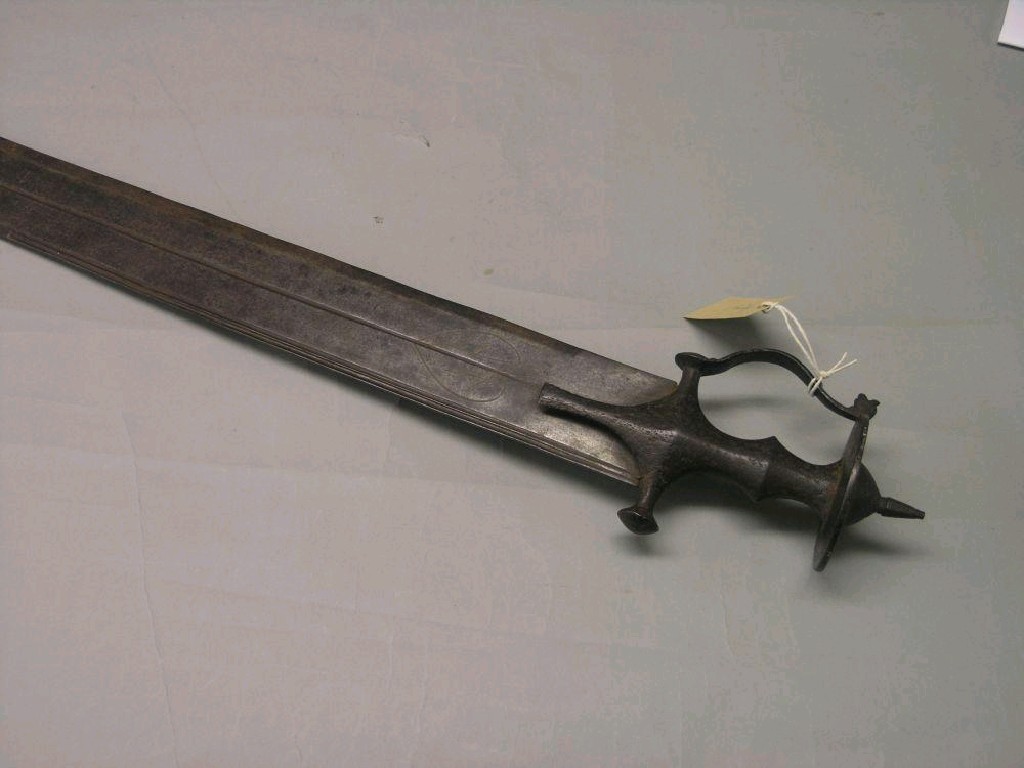 Appraisal: An Indian Tulwar with straight in double-edge sword