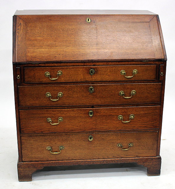 Appraisal: A GEORGE III OAK BUREAU the fall front opening to