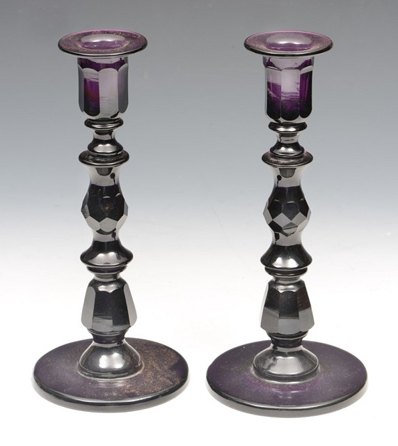 Appraisal: A PAIR OF AMETHYST GLASS CANDLESTICKS with facet cut baluster