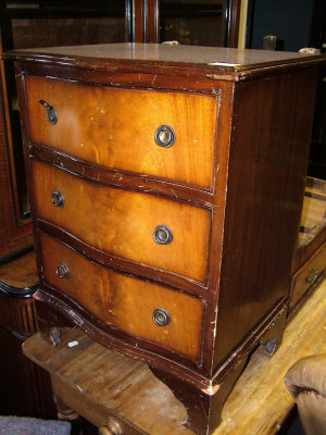 Appraisal: A small reproduction mahogany serpentine chest of three drawers upon