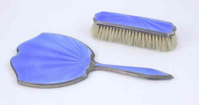 Appraisal: A silver and blue enamel hand mirror and clothes brush