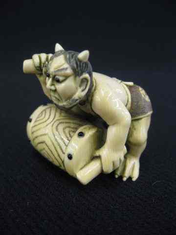 Appraisal: Carved Ivory Netsuke of an Oni with a drum signed