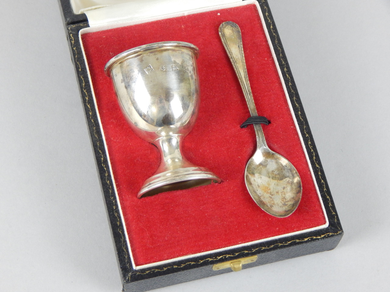 Appraisal: A modern silver egg cup and matching spoon in a