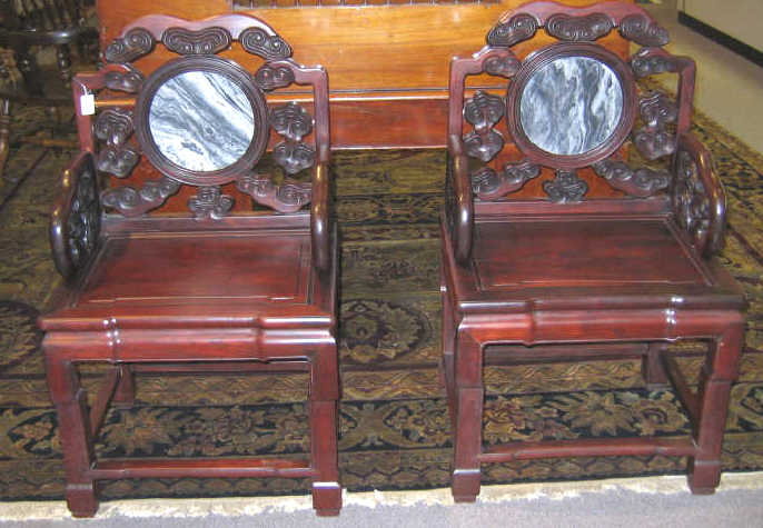 Appraisal: PAIR OF CHINESE HARDWOOD ARMCHAIRS The circular marble inset backs