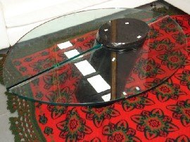 Appraisal: A round designer glass topped coffee table with granite pedestal