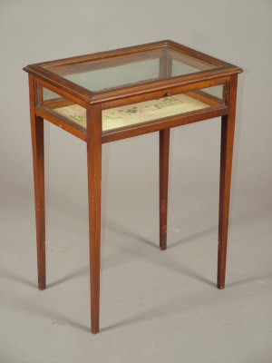 Appraisal: An Edwardian mahogany bijouterie table the glazed hinged lid above