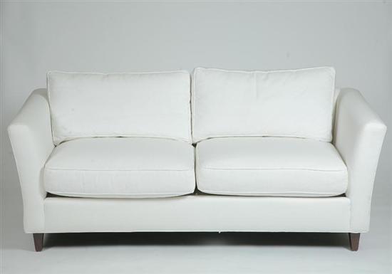 Appraisal: KRAVET UPHOLSTERED SOFA White sofa with four cushions on square