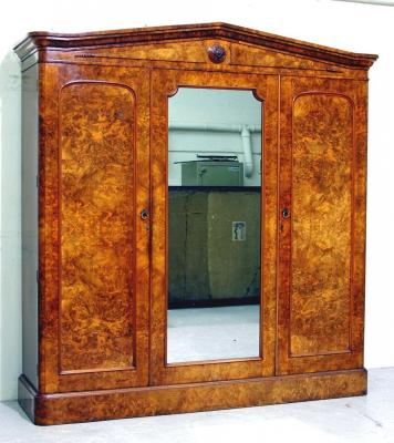 Appraisal: A VICTORIAN WALNUT TRIPLE WARDROBE the moulded pedimented top with