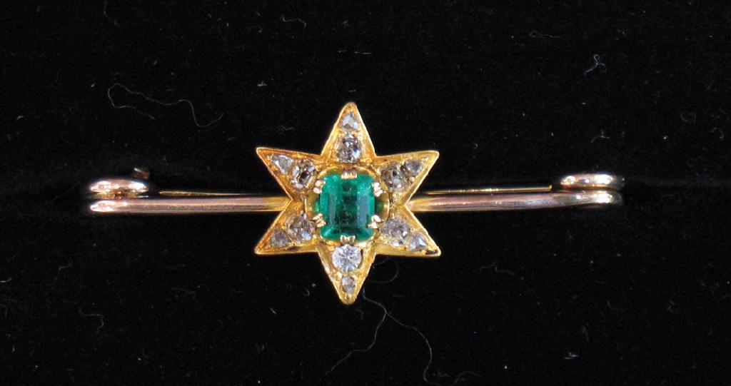 Appraisal: AN EMERALD AND DIAMOND BAR BROOCH the central step-cut emerald