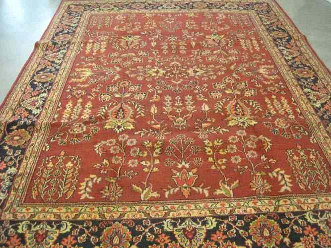 Appraisal: HAND KNOTTED ORIENTAL CARPET Indo-Sarouk floral sprig decoration on red