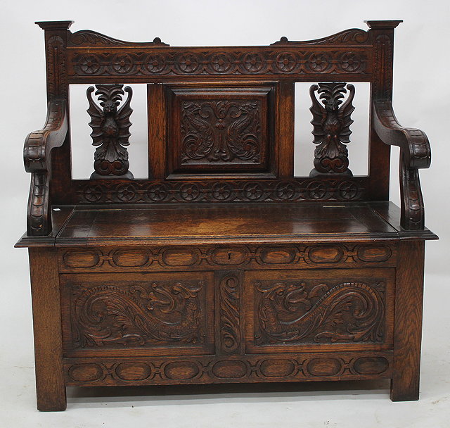 Appraisal: A OLD OAK CARVED BOX SEAT SETTLE with carved bat