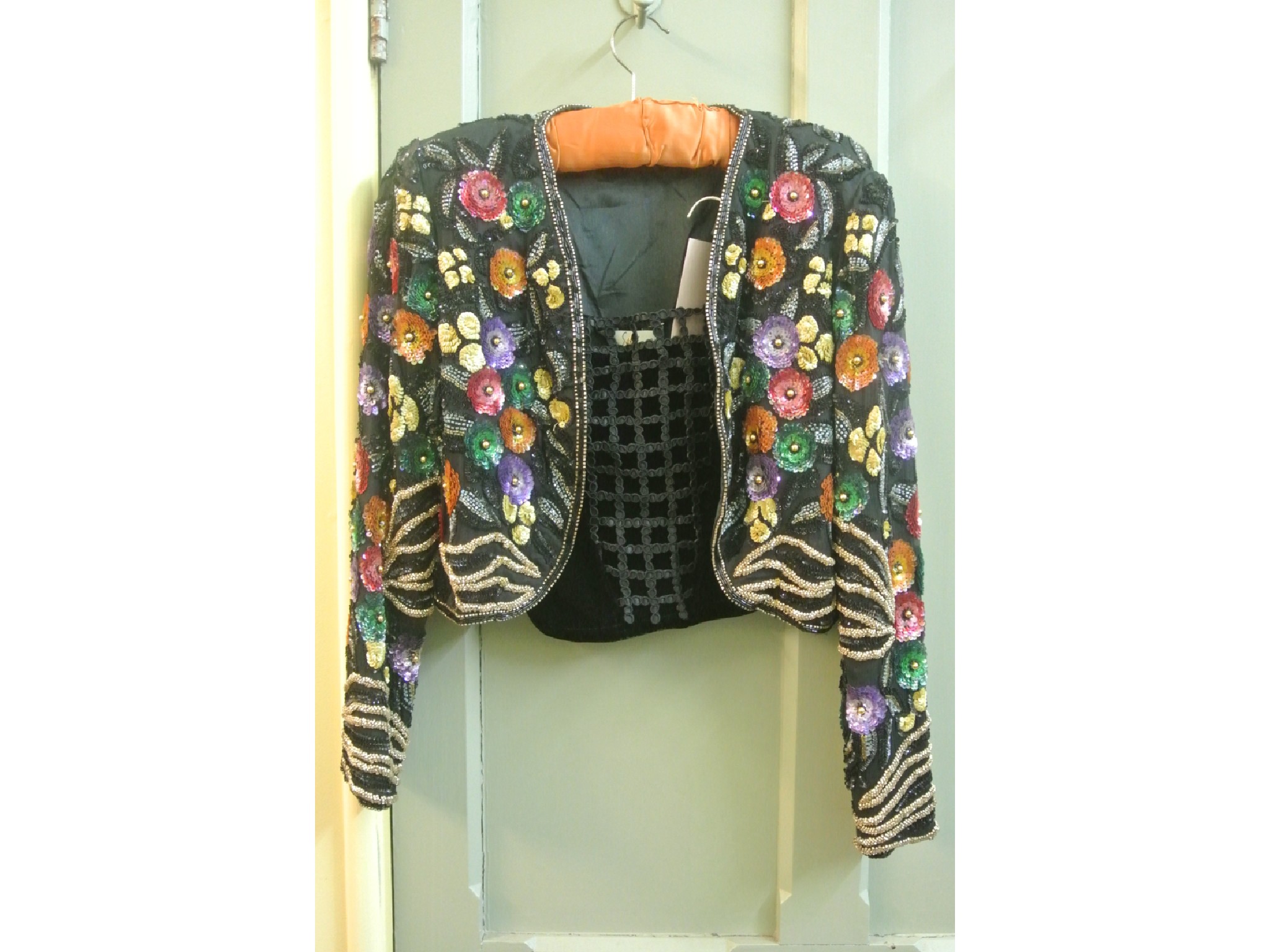 Appraisal: An evening jacket in black with colourful sequinned and applique