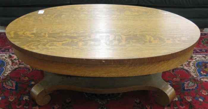 Appraisal: AN OVAL OAK COFFEE TABLE Empire Revival design American c