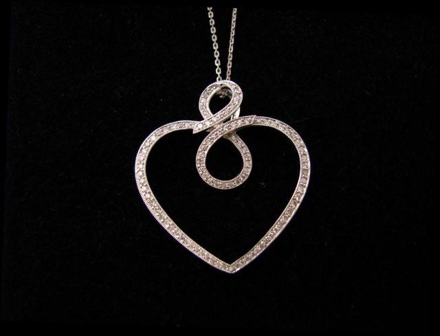 Appraisal: K white gold and diamond heart pendant with scroll motif