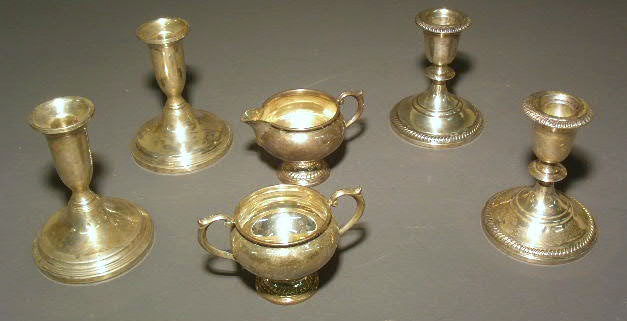 Appraisal: Four weighted sterling silver candlesticks and a sterling silver creamer