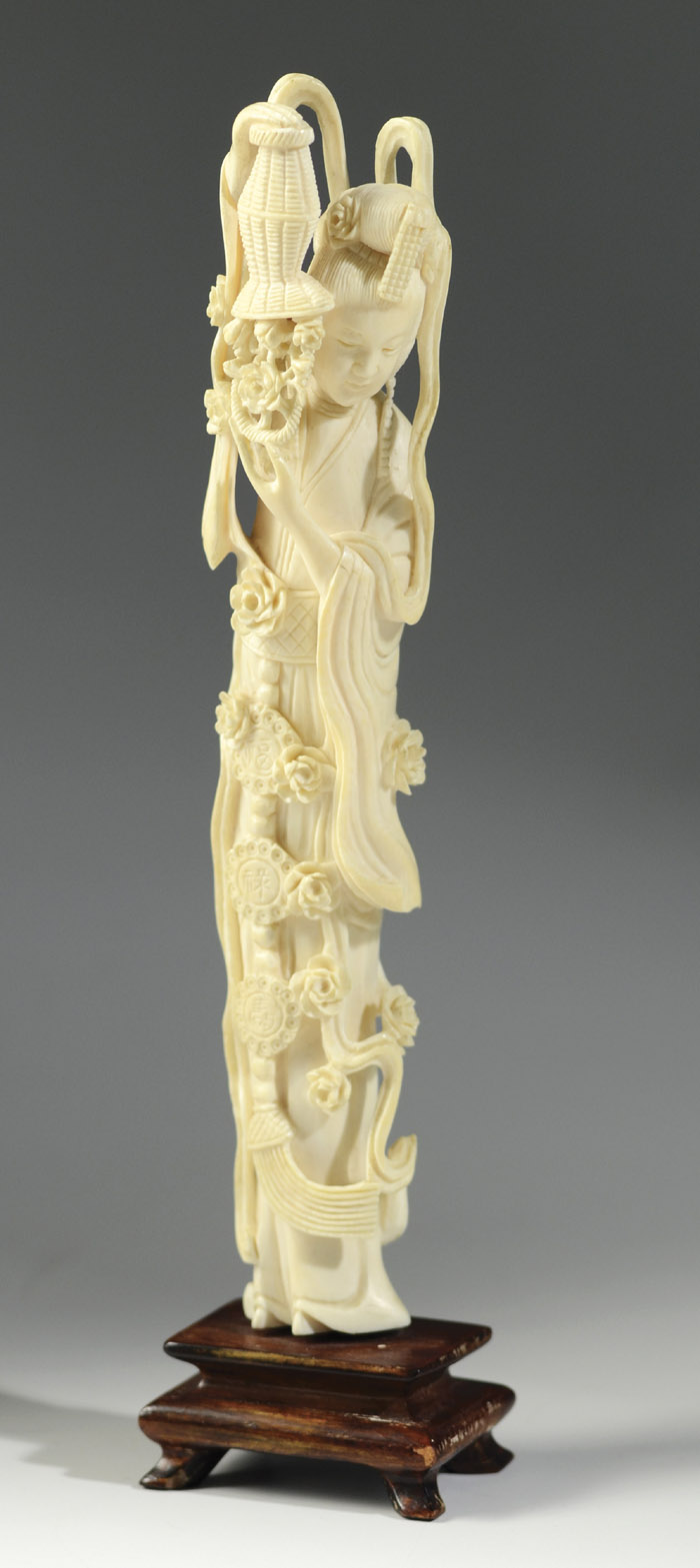 Appraisal: CHINESE CARVED IVORY QUAN YIN holding peony blossoms in an