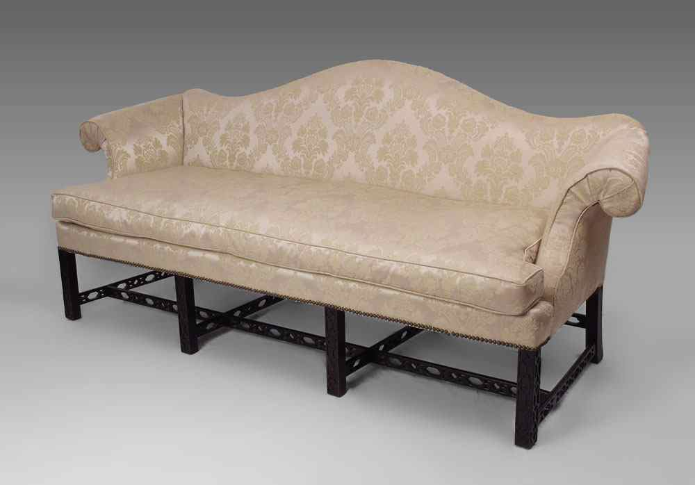 Appraisal: CARVED CHIPPENDALE CAMEL BACK SOFA Beige floral upholstered padded back