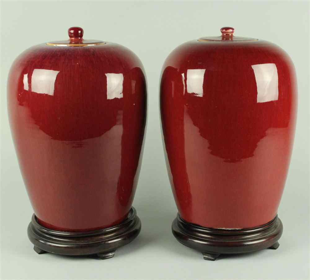 Appraisal: PAIR OF CHINESE SANG-DE-BOEUF-GLAZED JARS AND COVERS Of ovoid form