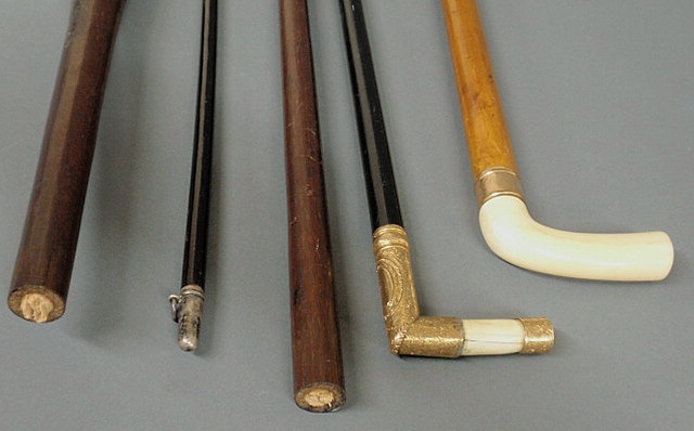 Appraisal: Two gold and bone ivory handled walking sticks approx l