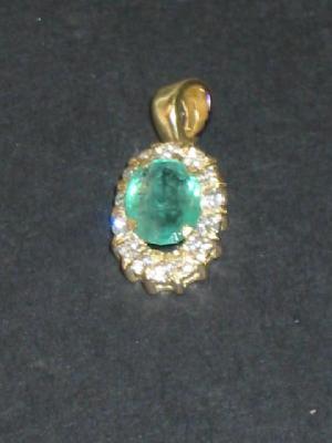 Appraisal: AN EMERALD AND DIAMOND PENDANT the central oval cut emerald