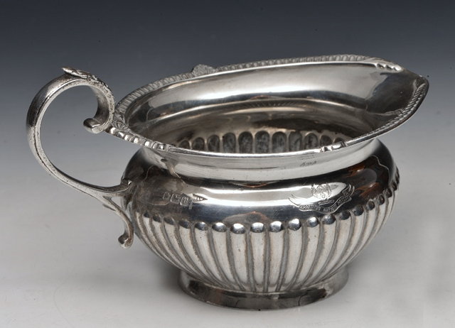 Appraisal: AN EDWARDIAN SILVER CREAM JUG with a fluted lower body