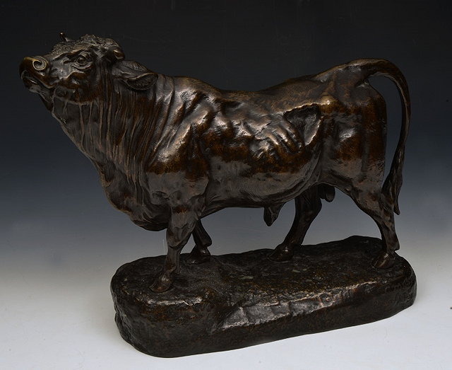 Appraisal: A BRONZE SCULPTURE of a bull standing upon naturalistic base