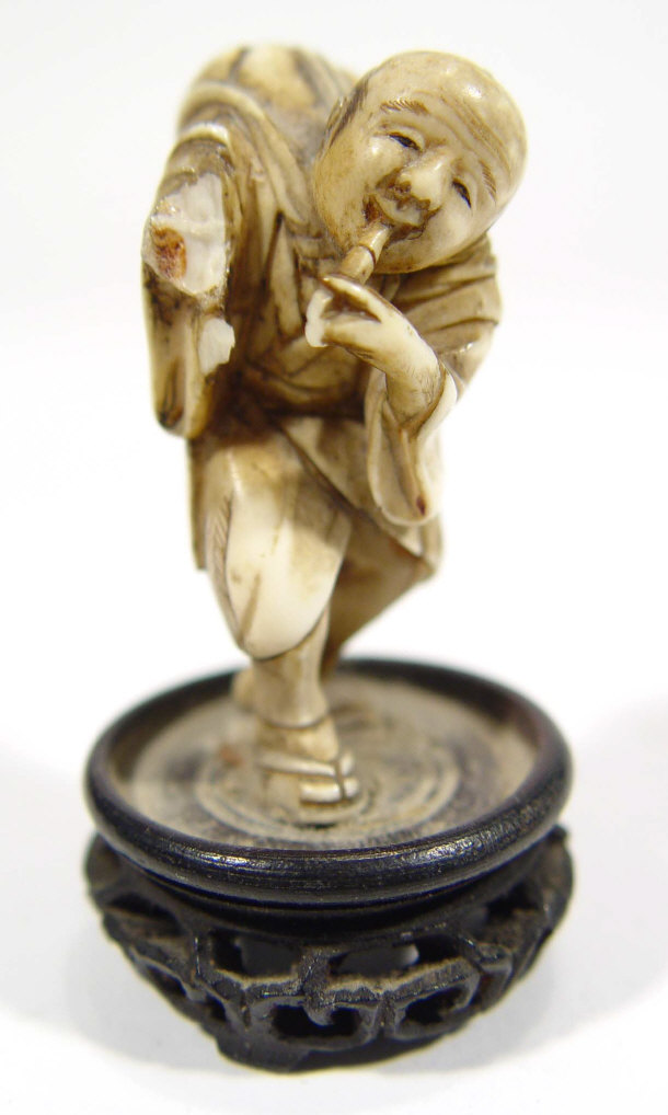 Appraisal: Oriental carved ivory okimono figure with pipe and bag on