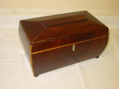 Appraisal: A MAHOGANY TEA CADDY of bombe oblong form with stringing