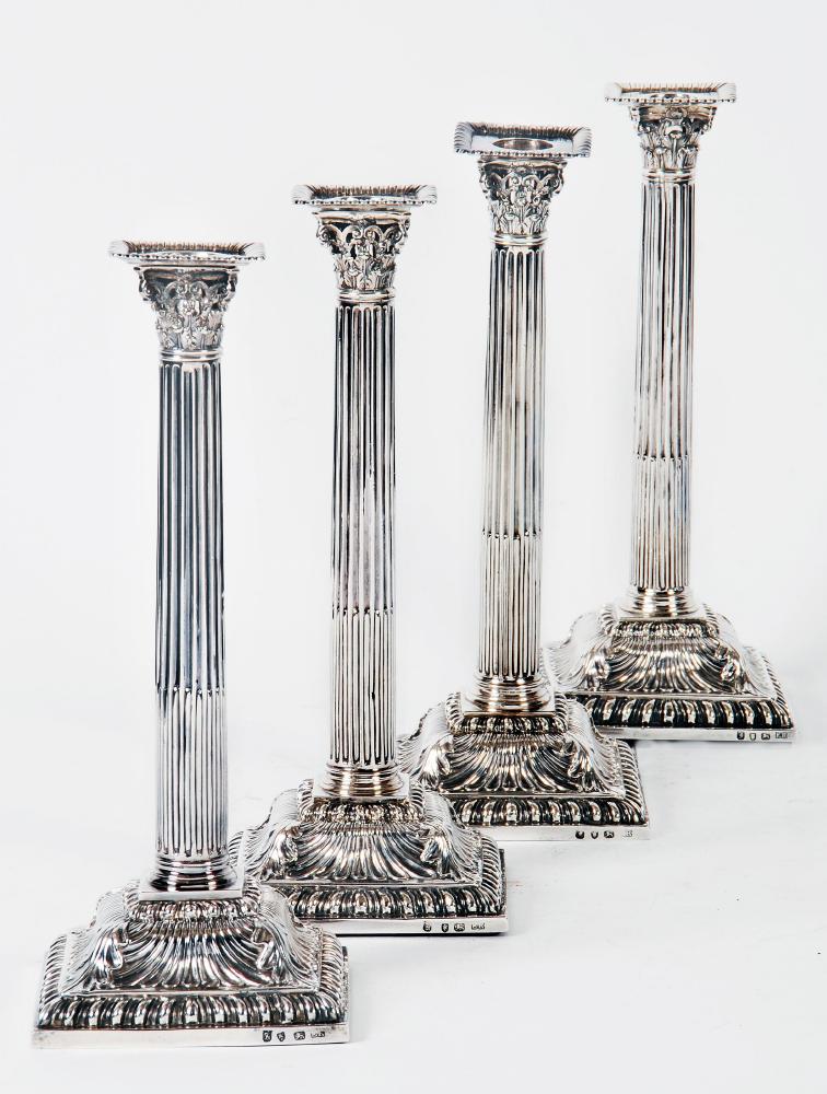 Appraisal: A SET OF FOUR EARLY GEORGE III CORINTHIAN COLUMN CANDLESTICKS