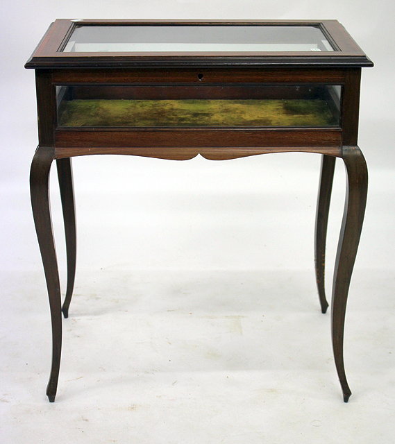 Appraisal: A MAHOGANY BIJOUTERIE TABLE the glazed lifting lid enclosing a