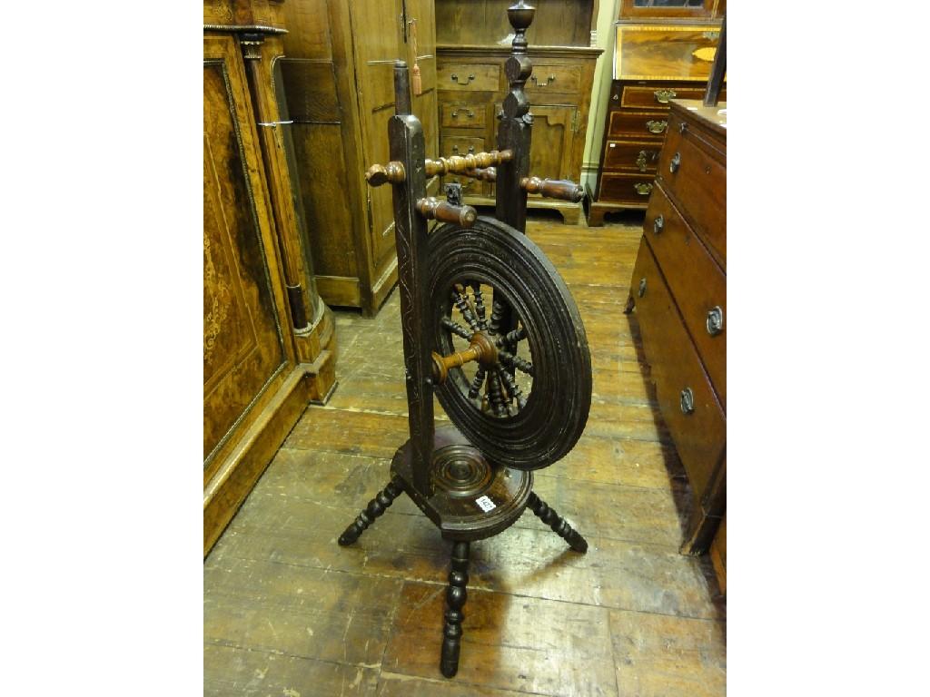 Appraisal: An antique oak spinning wheel with carved detail circular shaped